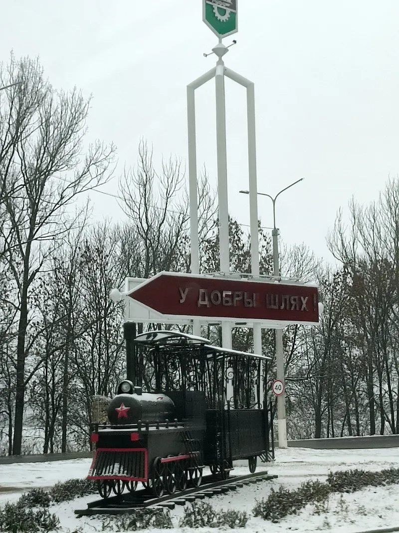 巴拉诺维奇雪地中的黑色蒸汽机车、城市标志与光秃的树木