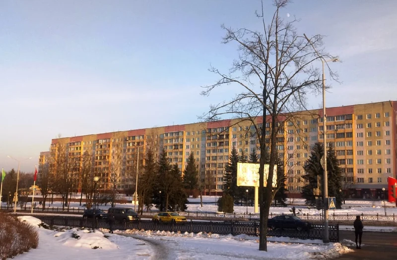新波洛茨克卡利宁街的积雪人行道、沿街住宅与冬日暖光