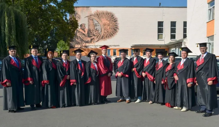 戈梅利国立大学（弗朗西斯克·斯科里纳）所供照片中身着学位服的人们在日月图案墙面前合影